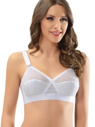 Une femme aux cheveux bruns longs et ondulés porte le Soutien-gorge raffermissant minimiseur NBB 3661, un soutien-gorge blanc au subtil motif pointillé. Le soutien-gorge présente de larges bretelles et une bande épaisse sous la poitrine. Elle sourit et regarde légèrement de côté sur un fond blanc uni.